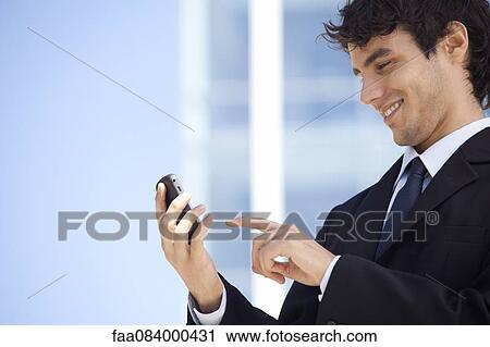 Young executive using cell phone outdoors View Large Photo Image Stock Image - Young executive using cell phone outdoors. Fotosearch