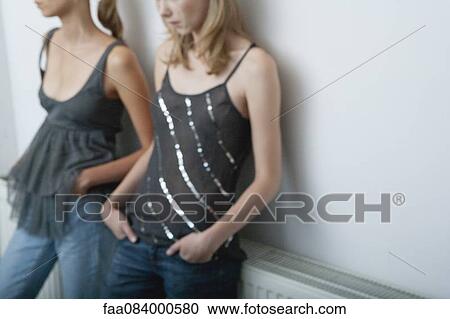 Young woman and teenage girl leaning against wall, cropped View Large Photo Image Stock Image - Young woman and teenage girl leaning against wall, cropped. Fotosearch