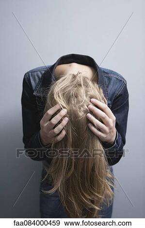 Stock Photo - Young woman bending over, tossing hair. Fotosearch
