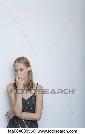 Stock Photograph - Young woman biting nails, portrait. Fotosearch