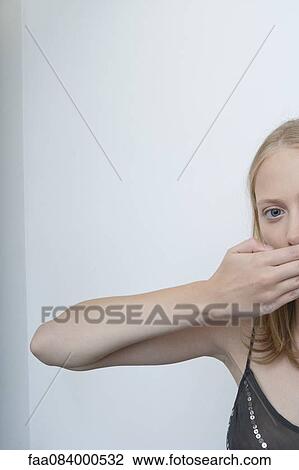Young woman covering mouth with hand View Large Photo Image Stock Image - Young woman covering mouth with hand. Fotosearch