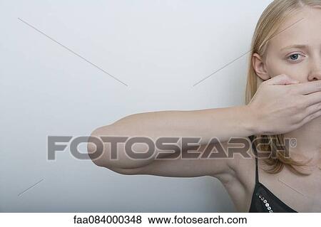Young woman covering mouth with hand View Large Photo Image Stock Photo - Young woman covering mouth with hand. Fotosearch
