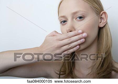 Young woman covering mouth with hand View Large Photo Image Stock Photography - Young woman covering mouth with hand. Fotosearch