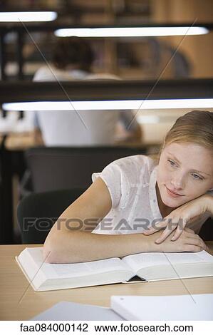 Young woman daydreaming while studying View Large Photo Image Stock Image - Young woman daydreaming while studying. Fotosearch