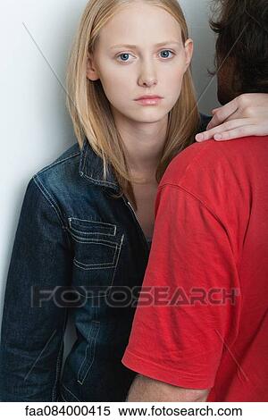 Young woman embracing man, looking at camera with serious expression View Large Photo Image Stock Photography - Young woman embracing man, looking at camera with serious expression. Fotosearch