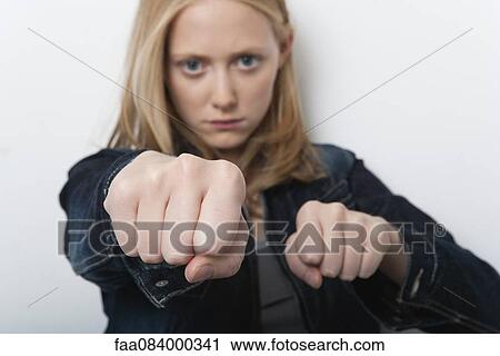 Young woman holding out clenched fists View Large Photo Image Stock Image - Young woman holding out clenched fists. Fotosearch