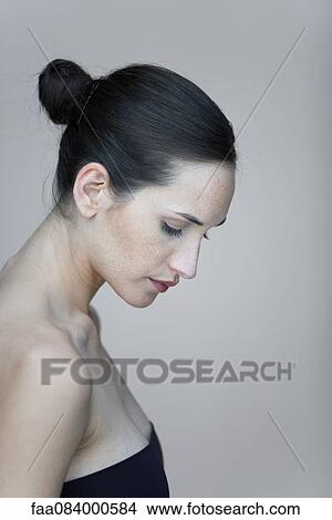 Picture - Young woman in profile, looking down, portrait. Fotosearch