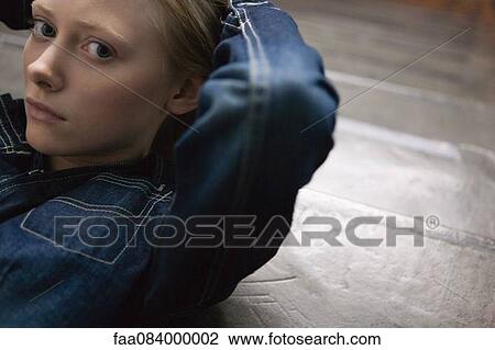 Young woman lying down with hands behind head View Large Photo Image Stock Image - Young woman lying down with hands behind head. Fotosearch