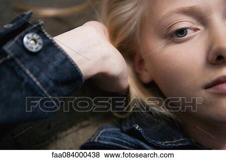 Young woman lying down with hands behind head, portrait View Large Photo Image Stock Photo - Young woman lying down with hands behind head, portrait. Fotosearch