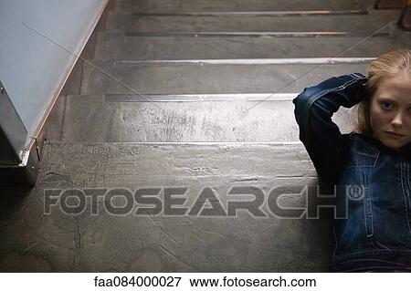 Young woman lying on stairs with hands behind head View Large Photo Image Stock Photo - Young woman lying on stairs with hands behind head. Fotosearch