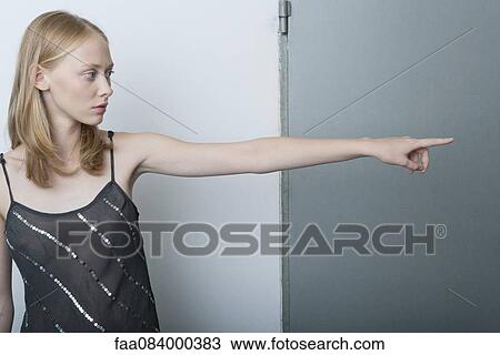 Young woman pointing and looking away View Large Photo Image Stock Image - Young woman pointing and looking away. Fotosearch