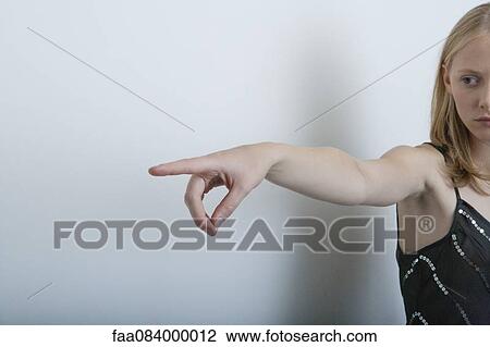 Stock Image - Young woman pointing finger. Fotosearch