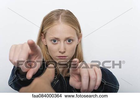 Young woman pointing fingers accusingly at person in foreground View Large Photo Image Picture - Young woman pointing fingers accusingly at person in foreground. Fotosearch