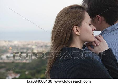 Stock Photograph - Young woman resting head on man's shoulder, rear view. Fotosearch