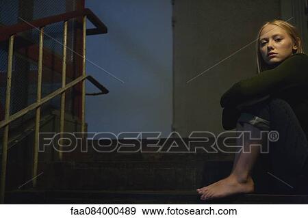 Young woman sitting on stairs, hugging knees View Large Photo Image Stock Photo - Young woman sitting on stairs, hugging knees. Fotosearch
