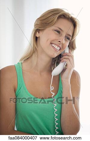 Young woman talking on landline phone View Large Photo Image Stock Photo - Young woman talking on landline phone. Fotosearch