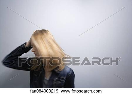 Young woman tossing hair, holding head View Large Photo Image Stock Photo - Young woman tossing hair, holding head. Fotosearch