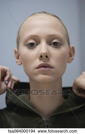 Picture - Young woman wearing hooded sweatshirt, portrait. Fotosearch