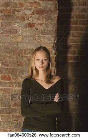 Stock Photo - Young woman with arms folded, portrait. Fotosearch