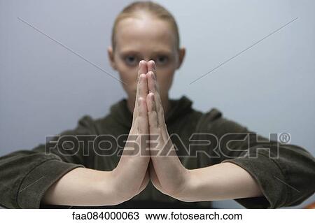 Young woman with hands clasped in prayer View Large Photo Image Stock Image - Young woman with hands clasped in prayer. Fotosearch