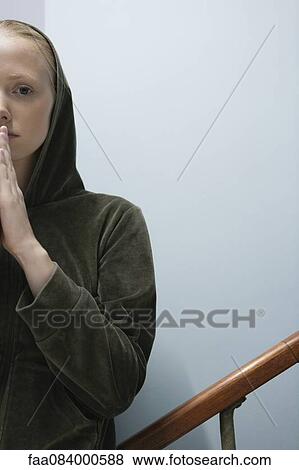 Stock Photo - Young woman with hands clasped in prayer. Fotosearch
