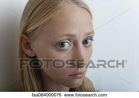 Stock Photograph - Young woman with worried expression, portrait. Fotosearch