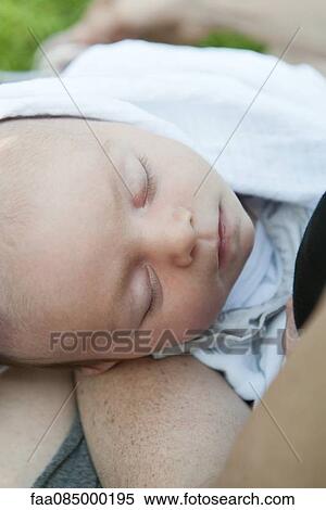 Stock Photography - Baby boy sleeping in mother's arms, cropped. Fotosearch