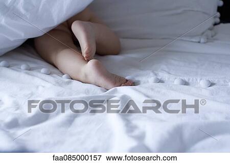 Baby crawling under duvet, cropped View Large Photo Image Stock Photo - Baby crawling under duvet, cropped. Fotosearch