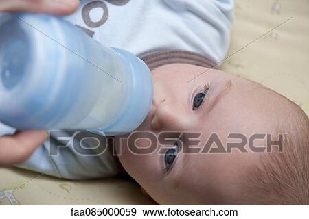 Stock Photo - Baby drinking from baby bottle. Fotosearch