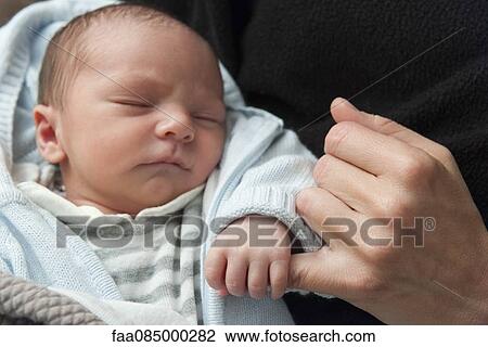 Stock Image - Baby holding adult's finger. Fotosearch