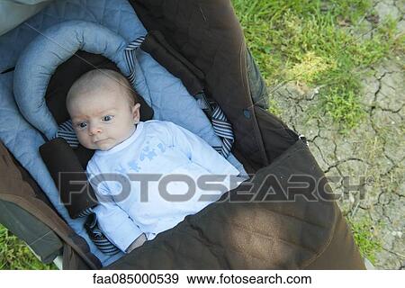 Stock Photo - Baby in baby carriage outdoors. Fotosearch