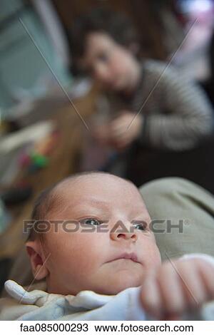 Stock Image - Baby lying on back, looking away. Fotosearch