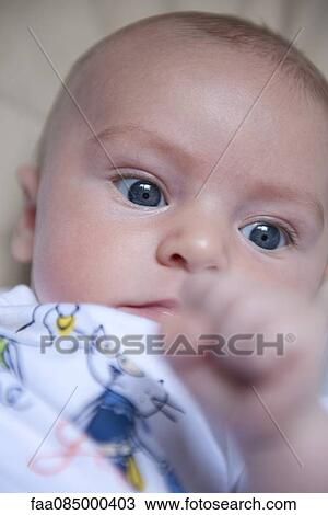 Baby lying on back with fist View Large Photo Image Stock Image - Baby lying on back with fist. Fotosearch