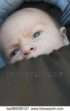 Stock Photo - Baby with face partially covered by blanket. Fotosearch