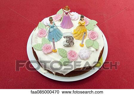 Stock Image - Birthday cake for three year old decorated with princess figurines. Fotosearch