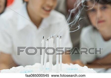 Stock Photography - Blown out candles on cake with smoke plume. Fotosearch