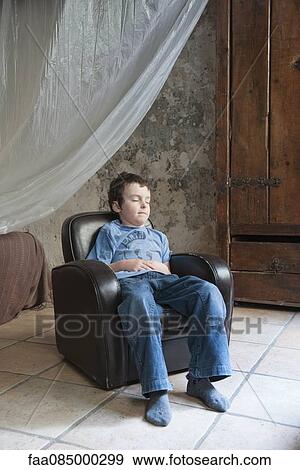 Boy napping in armchair View Large Photo Image Stock Photo - Boy napping in armchair. Fotosearch