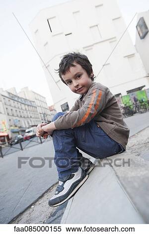 Boy sitting on curb, portrait View Large Photo Image Stock Photography - Boy sitting on curb, portrait. Fotosearch