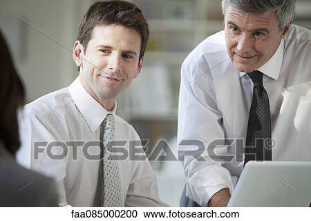 Stock Image - Business associates collaborating. Fotosearch