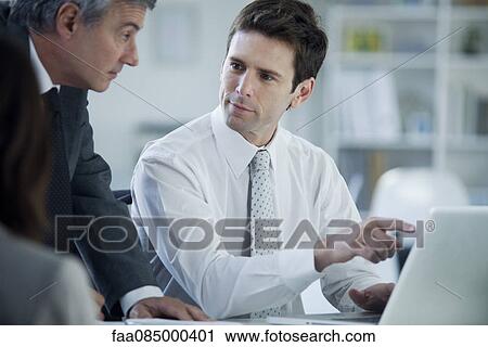 Business associates collaborating with laptop computer View Large Photo Image Stock Image - Business associates collaborating with laptop computer. Fotosearch