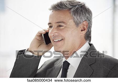 Business executive using cell phone View Large Photo Image Picture - Business executive using cell phone. Fotosearch