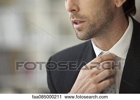 Businessman adjusting tie, cropped View Large Photo Image Stock Image - Businessman adjusting tie, cropped. Fotosearch