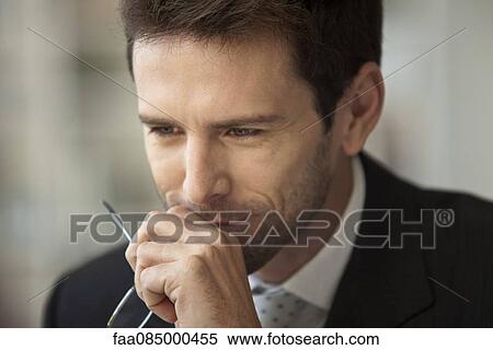 Stock Photography - Businessman looking away in thought. Fotosearch