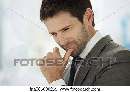 Stock Photography - Businessman looking down in thought. Fotosearch