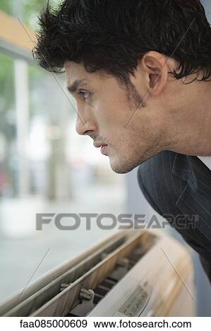 Stock Photo - Businessman looking out of window, side view. Fotosearch