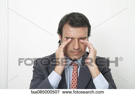 Stock Photo - Businessman rubbing eyes. Fotosearch