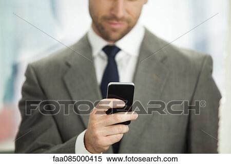 Businessman sending text message on cell phone, cropped View Large Photo Image Stock Photography - Businessman sending text message on cell phone, cropped. Fotosearch