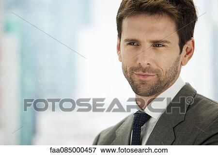 Businessman smiling and looking away in thought View Large Photo Image Stock Photo - Businessman smiling and looking away in thought. Fotosearch