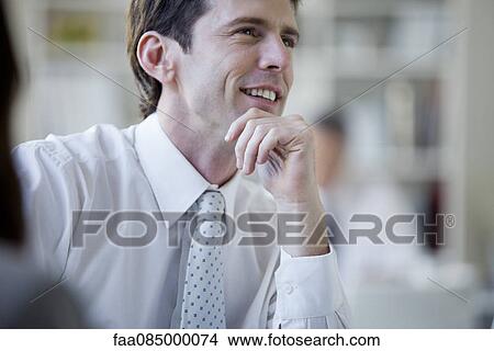 Businessman smiling, looking away in thought View Large Photo Image Picture - Businessman smiling, looking away in thought. Fotosearch