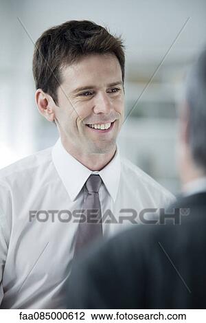 Businessman talking to colleague View Large Photo Image Stock Image - Businessman talking to colleague. Fotosearch